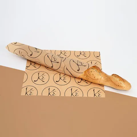 Baguette in a kraft greaseproof sheet with a repeat logo print